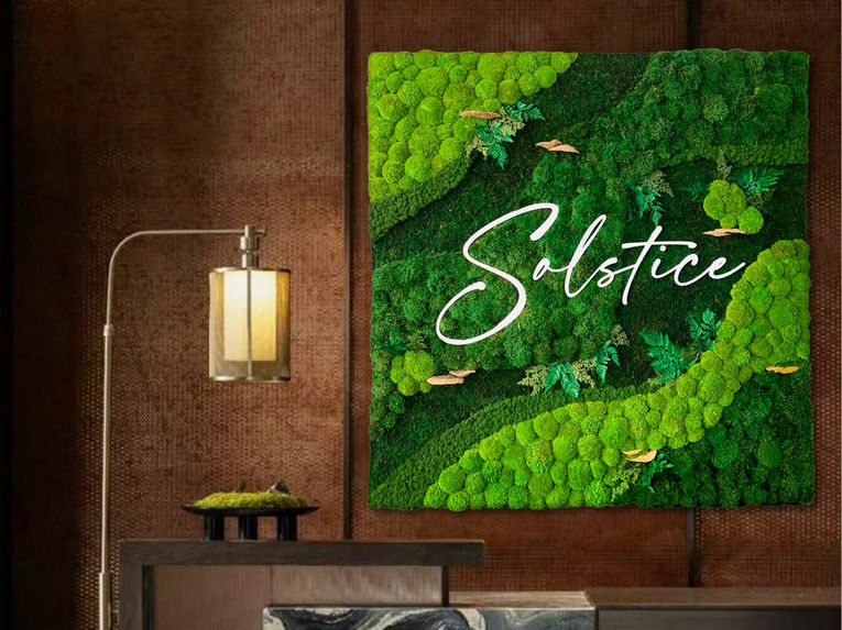 Custom preserved moss wall with integrated logo design, used as a decorative and branded feature in an upscale interior.