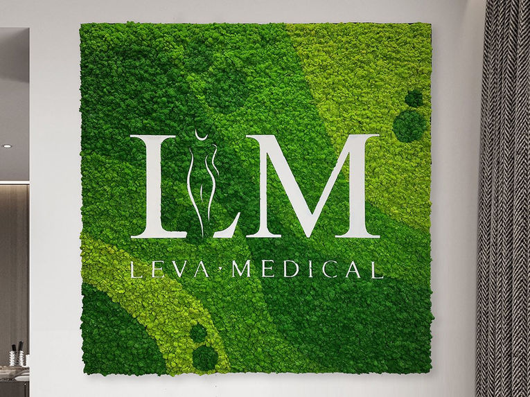 Leva Medical reindeer moss wall with large logo lettering in modern medical facility featuring preserved moss background and contemporary interior design