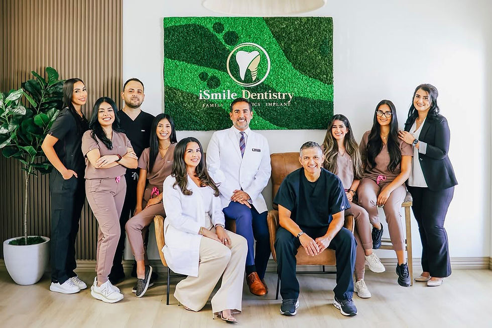 Professional dental team group photo at iSmile Dentistry with moss wall logo backdrop in modern dental office setting