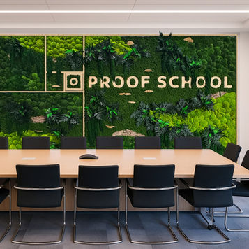 Proof School conference room featuring custom branded moss wall with mixed preserved moss textures, modular panels displaying school logo, and biophilic design in educational meeting space