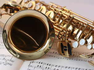 Saxophone laying sideways on sheet music
