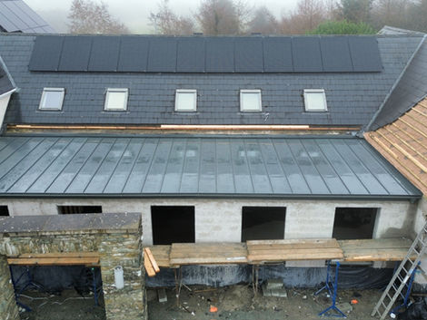 Zinc flat roof integrated with the existing building structure and rooflines.