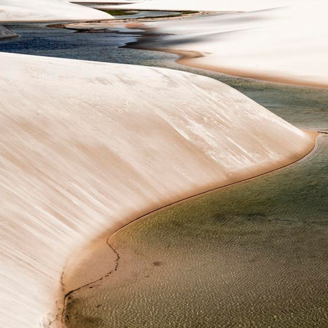 rio correndo para o fundo em meio as dunas