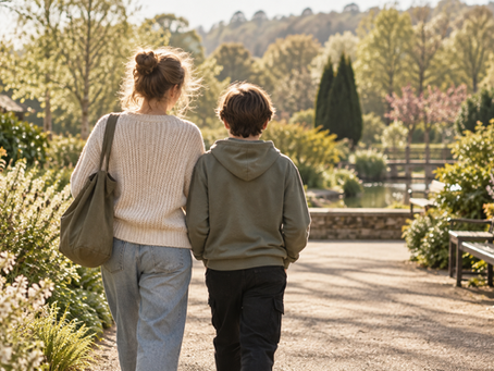 Illustrative, unidentifiable parent and child walking together in a garden, seen from behind