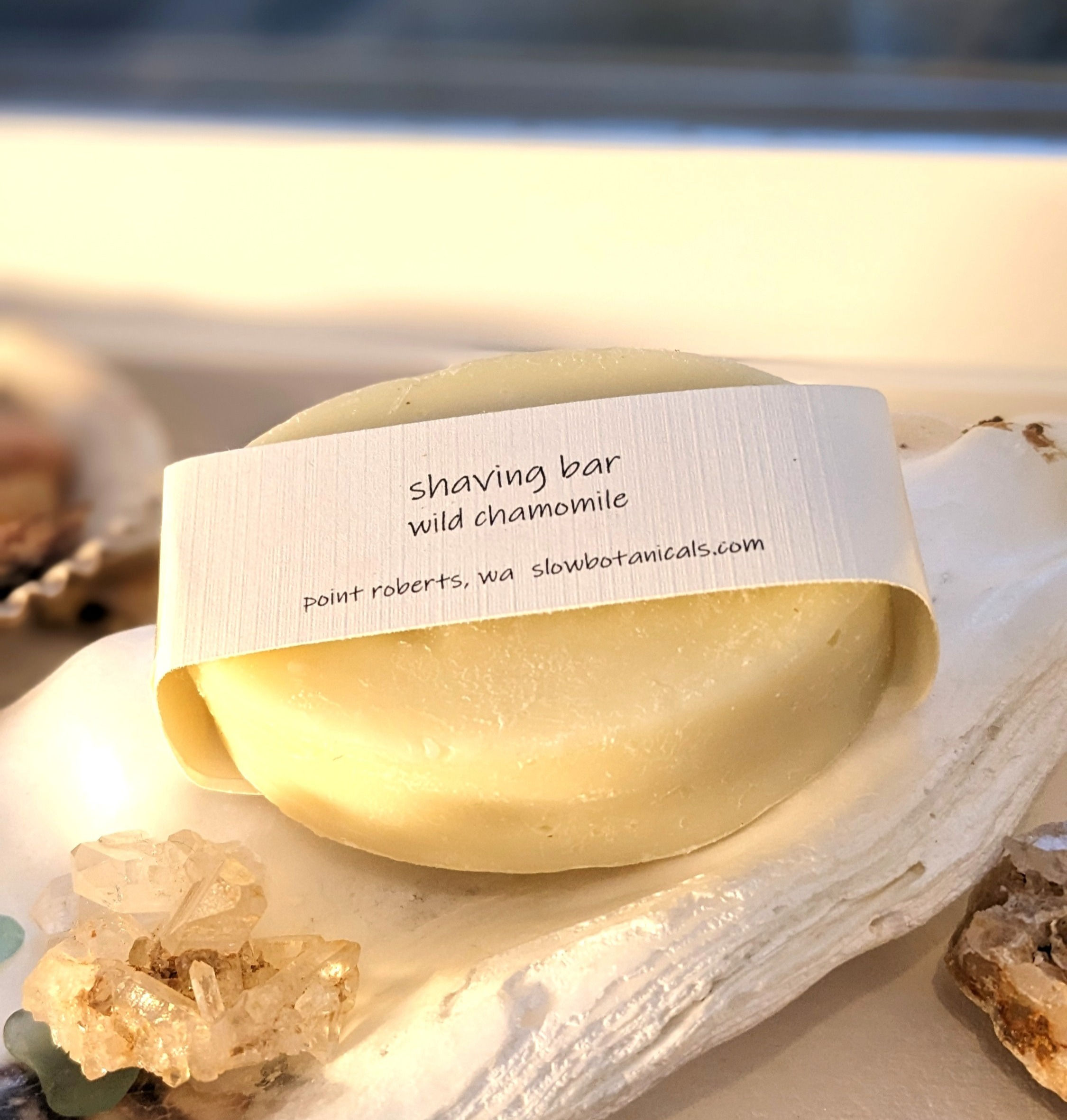 Above and front view of clean shave soap by Slow Botanicals. Bar on white soap dish.