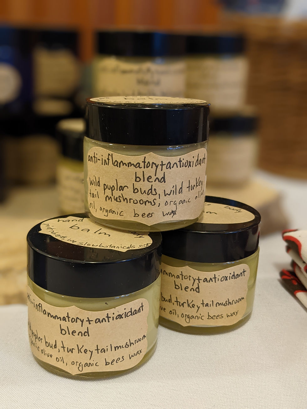 Stack of glass jars of wild poplar bud and wild turkey tail mushroom skin cream by slow botanicals