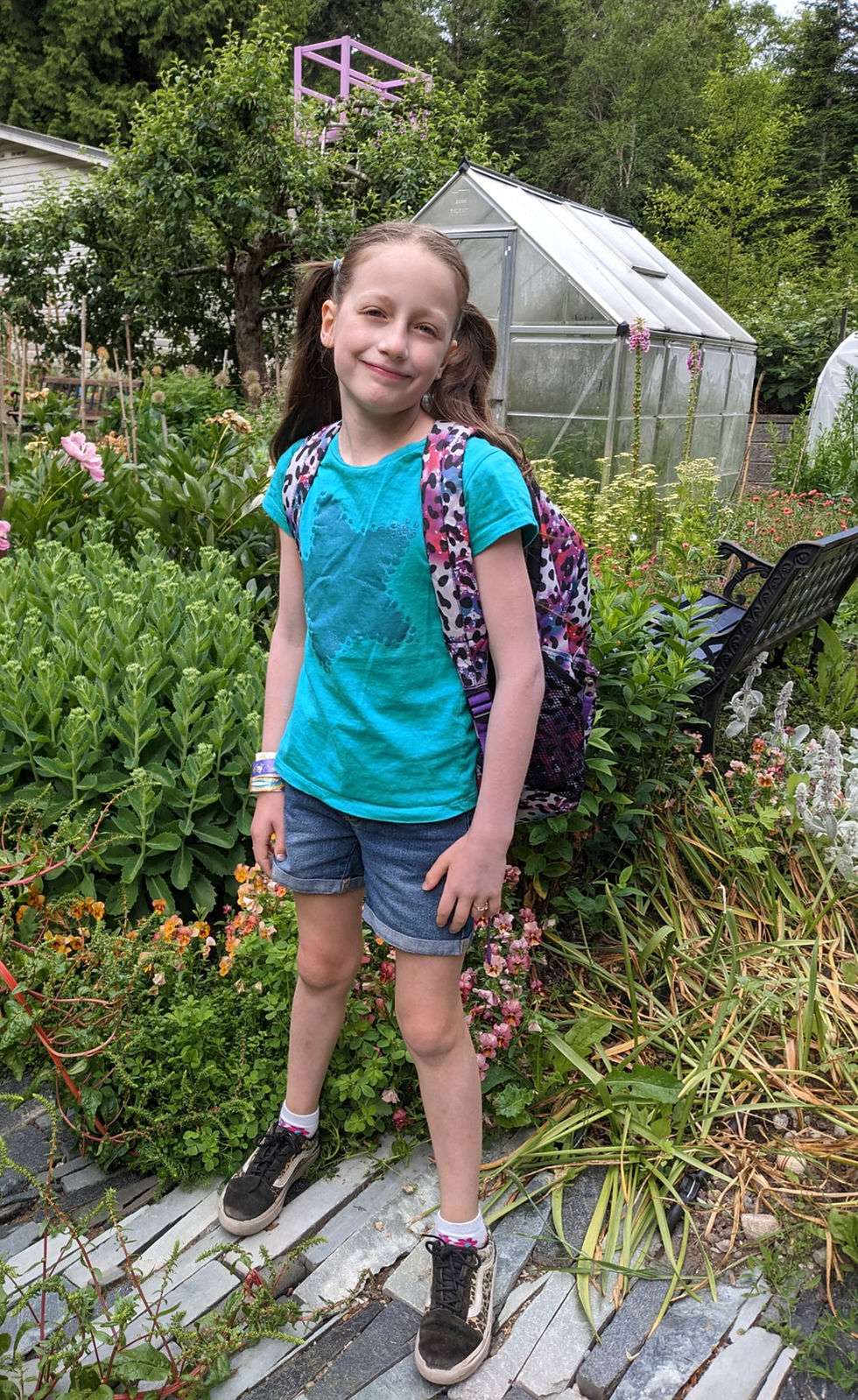 Little girl standing in garden full of flowers