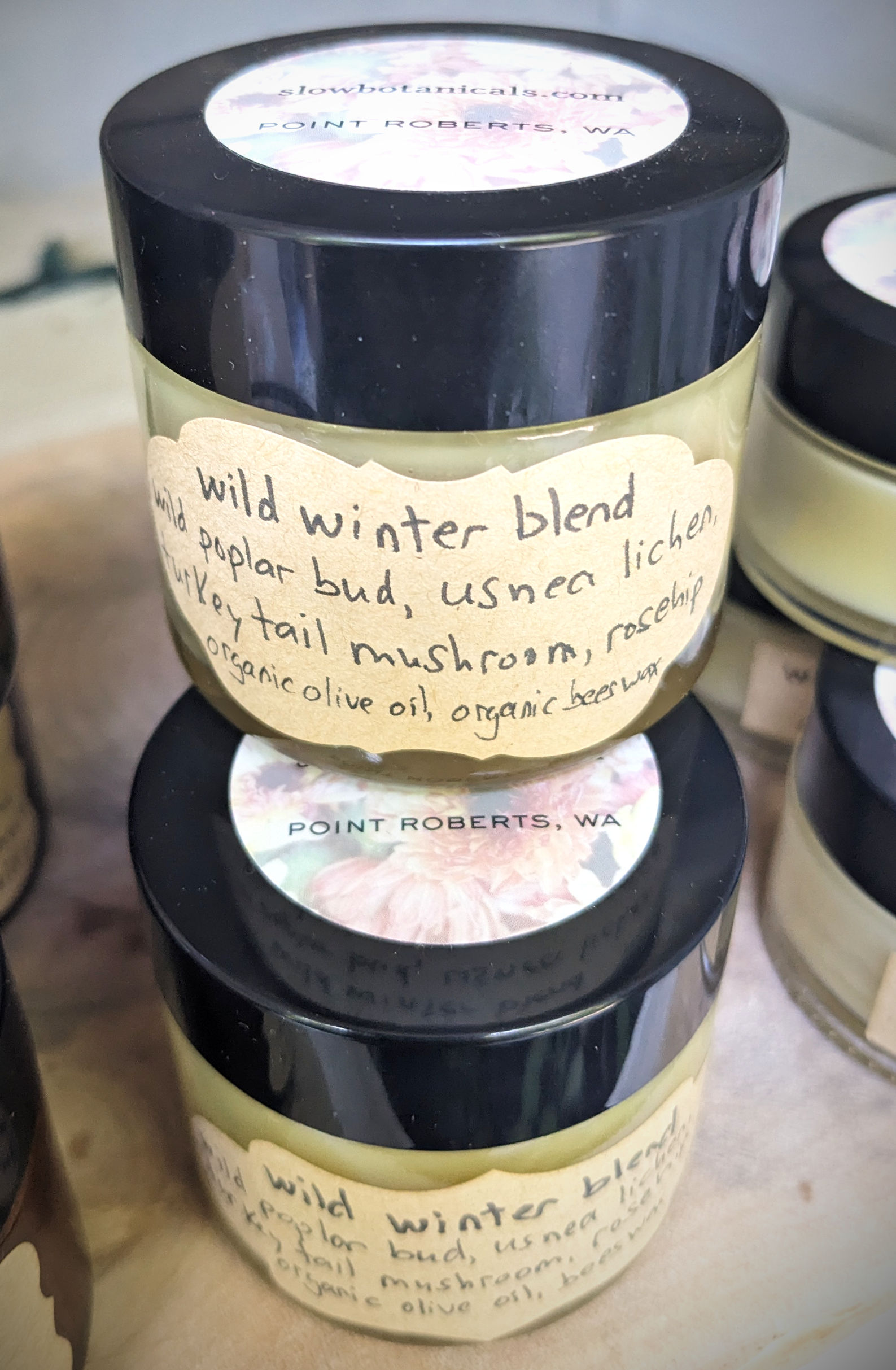 Front view of stacked glass jars of wild winter blend skin cream by slow botanicals
