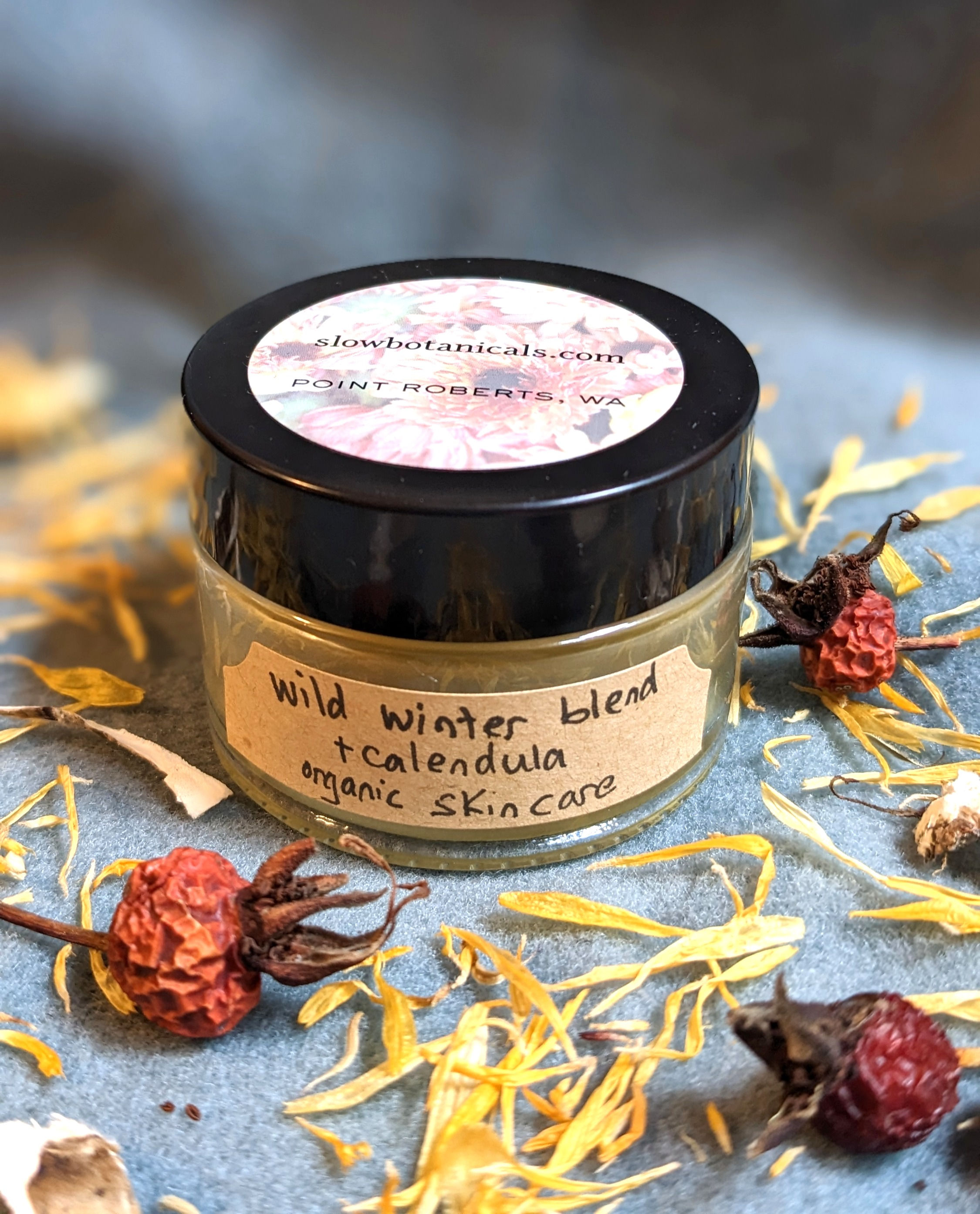 Glass jar of artisan cream made with winter picked ingredients plus garden grown calendula