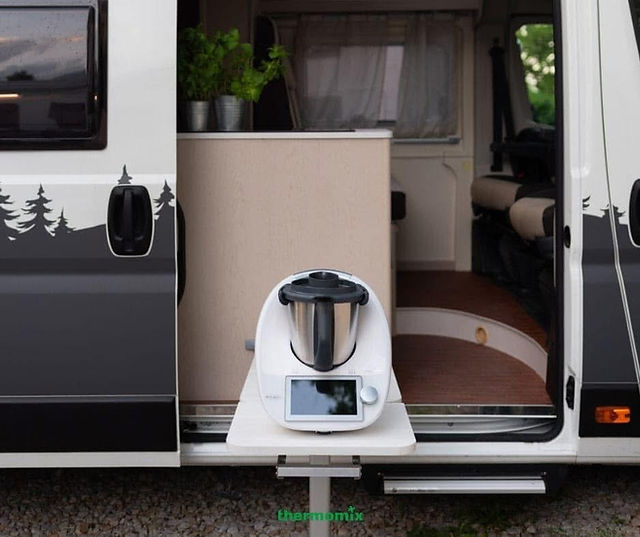 Thermomix TM6 on a small worktop inside a campervan, cooking while parked in a scenic countryside location.