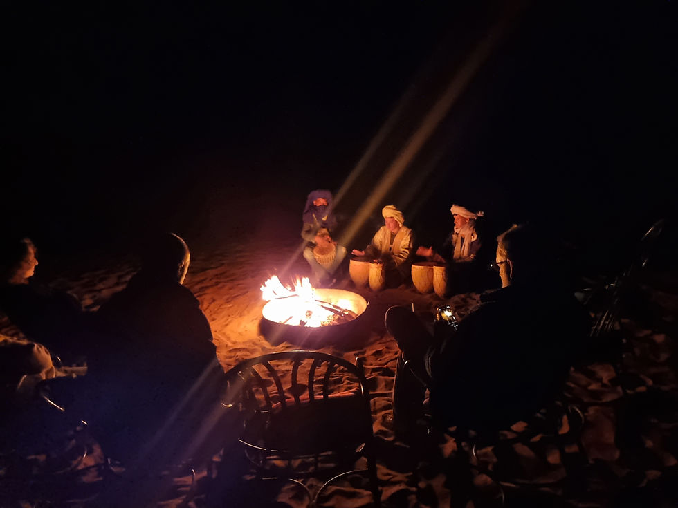Pilotes réunis autour du feu de camp le soir, bivouac de raid moto Soultracks Expédition
