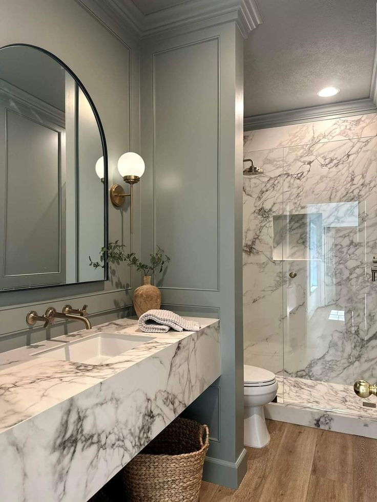 The guest bath vanity features a full-length front apron, plus a fully walled and floored walk-in shower, all in Calacatta Extra marble - Old Metairie, LA