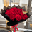 Thumbnail: Hand holding Bouquet of 100 Red Roses, wrapped in black paper with butterfly.