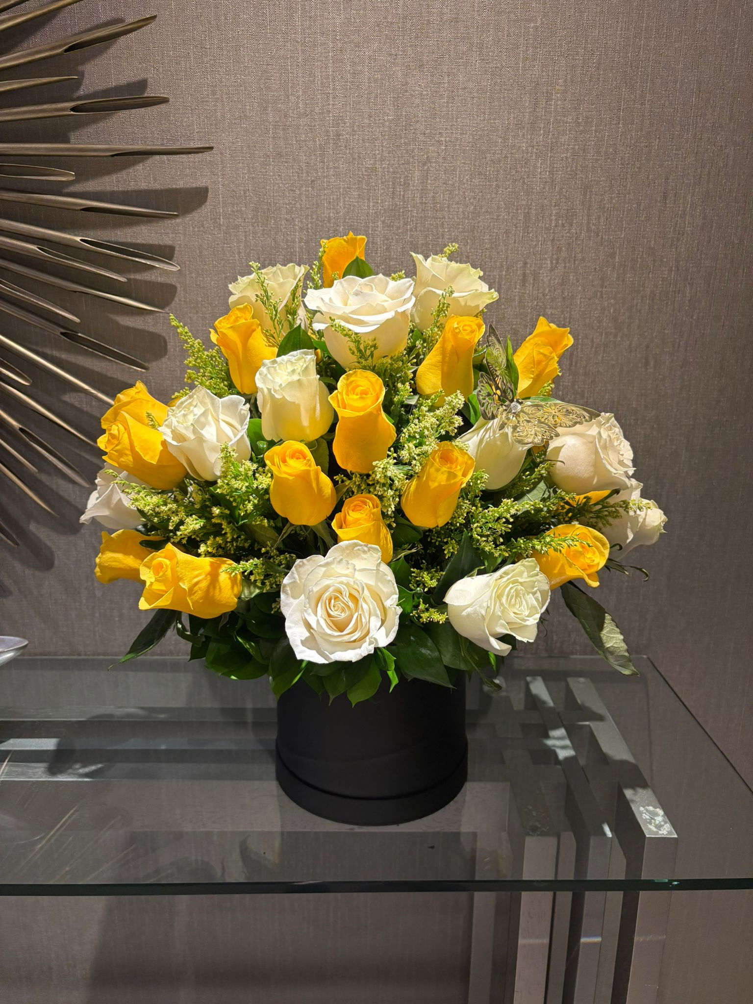 Beautiful bouquet of white and yellow roses in a black vase.
