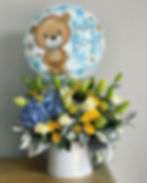 Baby Boy balloon above a floral arrangement of hydrangeas, lilies and Doral Blooms.
