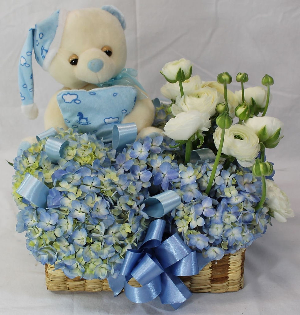 Blue and white floral arrangement with a teddy bear, bow, and basket.