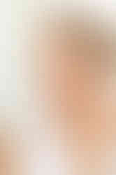 a woman is applying foundation to her face and smiling