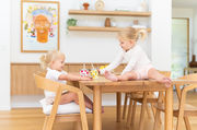 two little girls sitting on dining table with smoothie cups