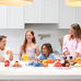 Four child models laughing in the kitchen of a Gold Coast shoot location for children's product brand roomie jr, shot by MNDY Photography