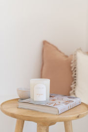 a candle called origins sits on top of a book