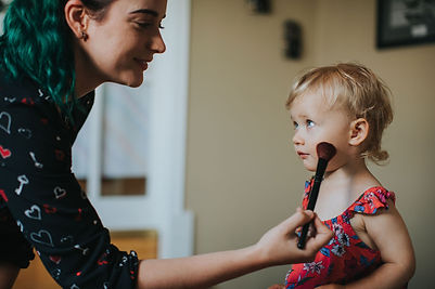 Tanaya Hachey applying blush to a young flower girl