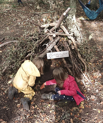Muddy Mountains forest school children making an A-type debris shelter.