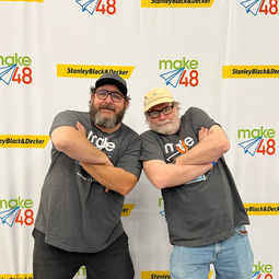 tool techs chris and luke being silly in front of the stanley black and decker step and repeat banner