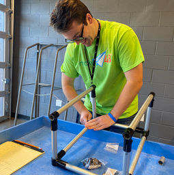a contestant working on his prototype using maker pipe items