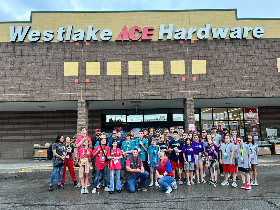 30 students and a few adults standing in front of Ace Hardware store