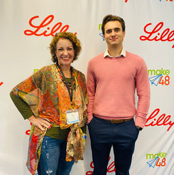 Two patent attorneys standing together in front of the lilly step and repeat banner