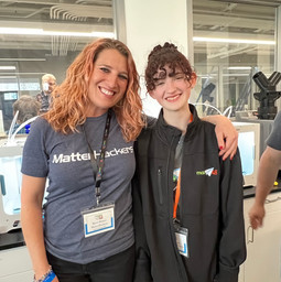 tool techs mara and piper standing next to each other in front of 3d printers