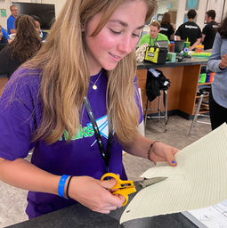 team members from stellar tech girls using olfa scissors to cut a piece of paper