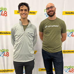 two tool techs standing next to each other in front of the stanley black and decker step and repeat banner