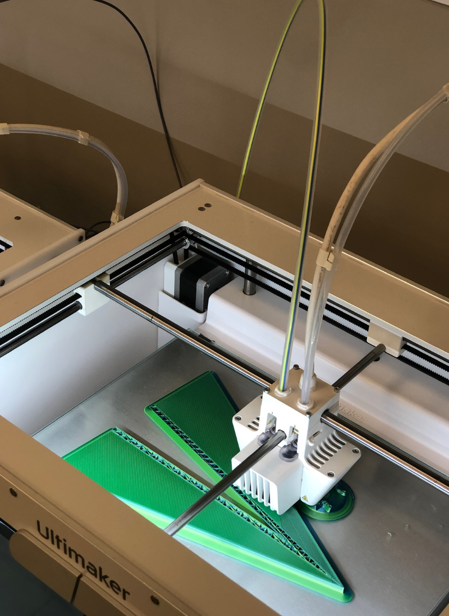 3d printer printing a green airplane