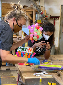 tool techs joanie and anika working on the kids choice trophy with balloons