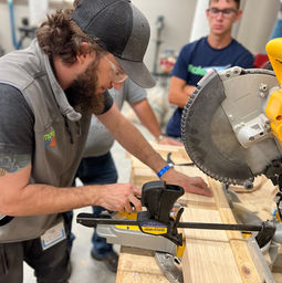 tool tech tyler working at a saw with wood