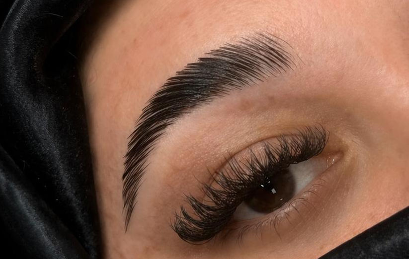 Close-up of eyebrow lamination showing lifted, brushed-up brows with fuller, defined shape and smooth hair alignment.