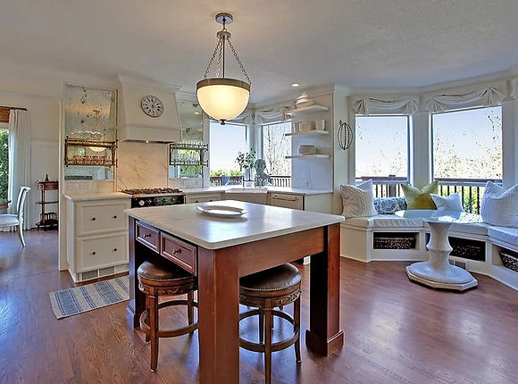 Luxury kitchen remodel featuring custom cabinetry, marble countertops, hardwood floors, and built-in window seating