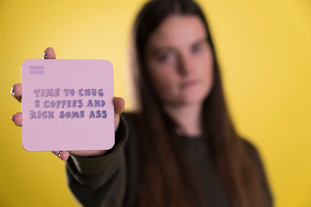 Girl holding up a quote card. Blog on Positivity by Cheltennham Lifestyle and Business.
