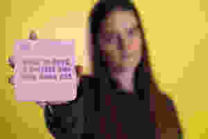 Girl holding up a quote card. Blog on Positivity by Cheltennham Lifestyle and Business.