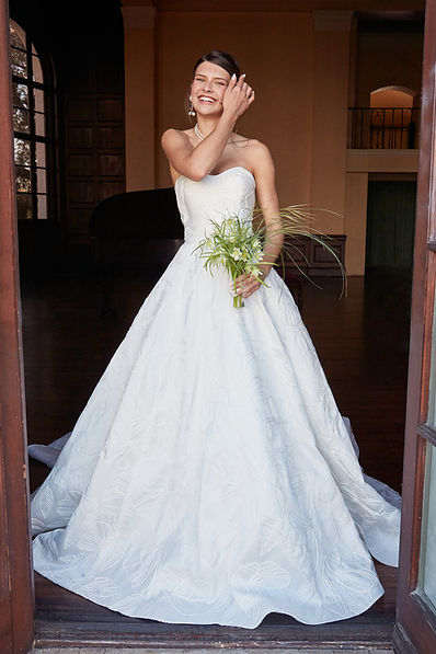 Beautiful bride in a white dress standing in a doorway smiling