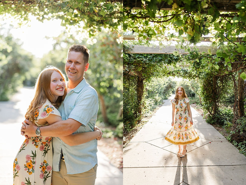 Father and daughter in floral dresses embrace, smiling under a leafy archway, with sunlight creating a warm, cheerful atmosphere.