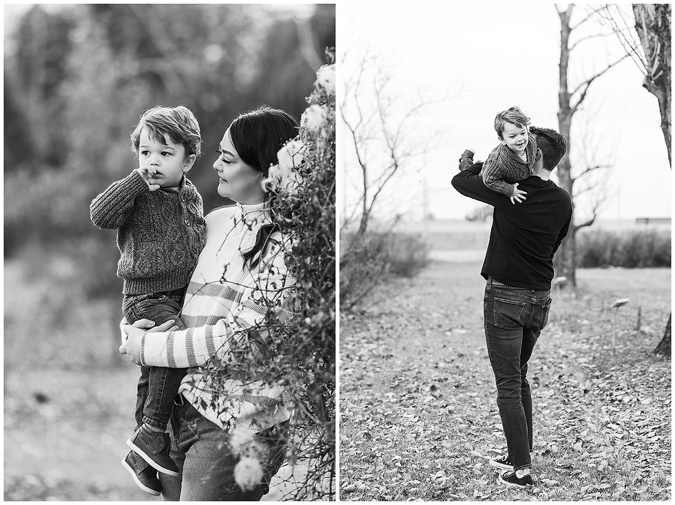 mom and dad playing with son in black and white