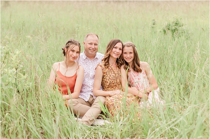 Family sitting in tall grass