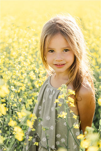 Young girl standing in canola field