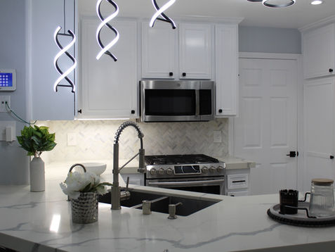 Modern kitchen with sleek appliances and unique lighting fixtures.