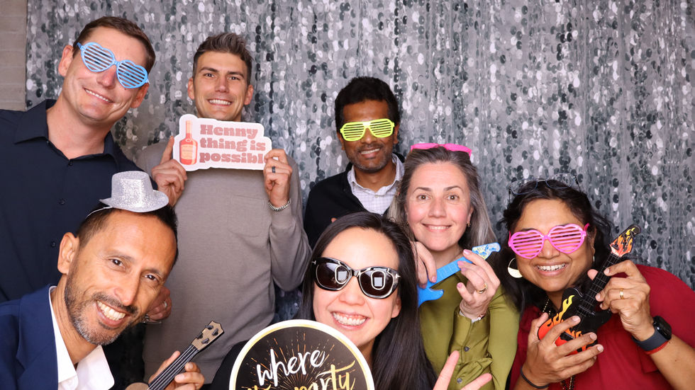 Group of people posing with party props.