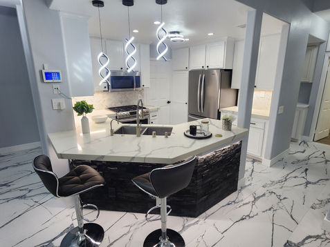 Modern kitchen with sleek design and marble flooring.