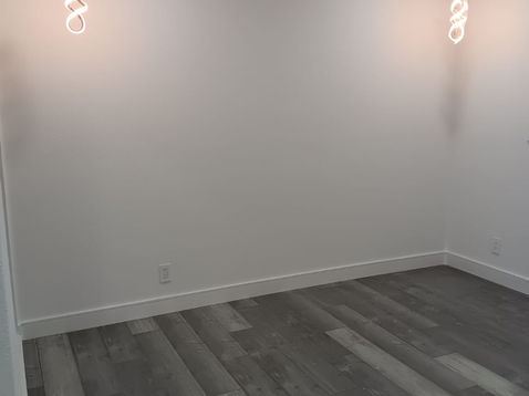 Empty room with wooden floor and wall lights.