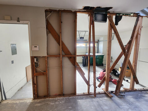 Partially demolished wall in a residential interior space.